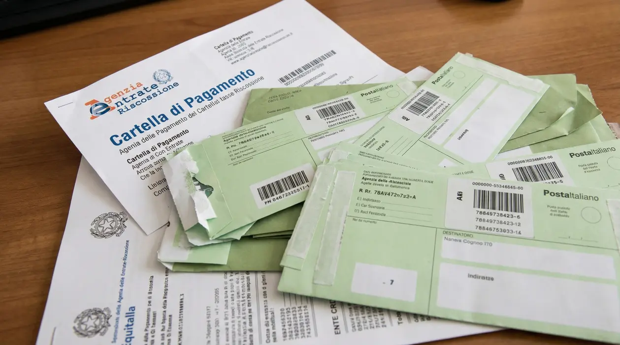 Documenti ufficiali e cartelle esattoriali su un tavolo di legno