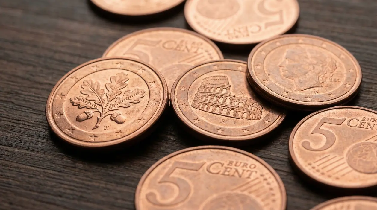 Monete da 5 centesimi euro disposte su una superficie in legno