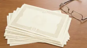 Una pila di buoni fruttiferi postali su un tavolo di legno accanto a un paio di occhiali