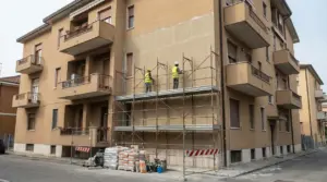 Operai al lavoro su ponteggi per il rifacimento della facciata di un edificio condominiale