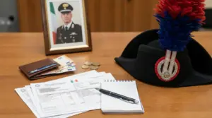 Scrivania con documenti, berretto da carabiniere e portafoglio con denaro